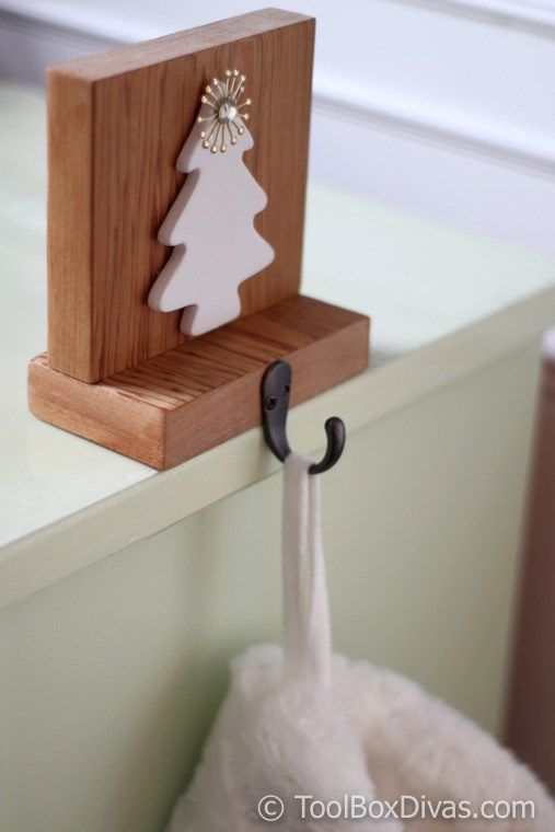 a wooden stand with a white christmas tree on it and an umbrella hook attached to it