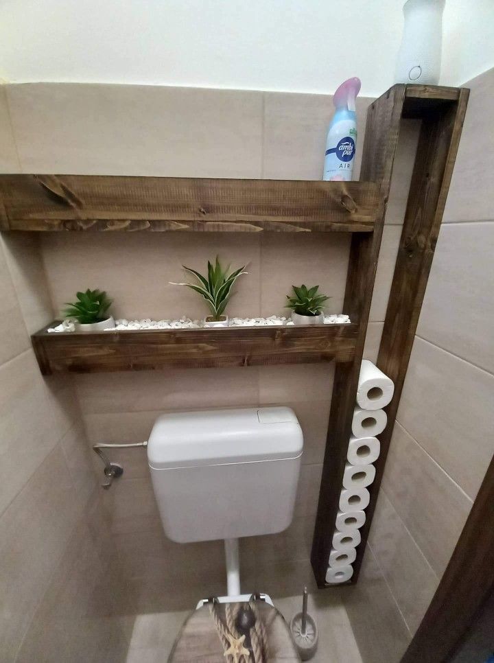 there is a toilet in the bathroom with some plants on the shelf above it and a towel rack next to it