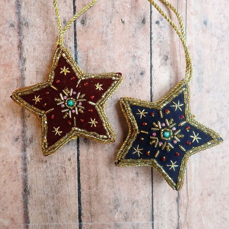 two ornaments are hanging on a wooden surface