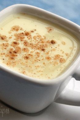 a white cup filled with cream and topped with cinnamon