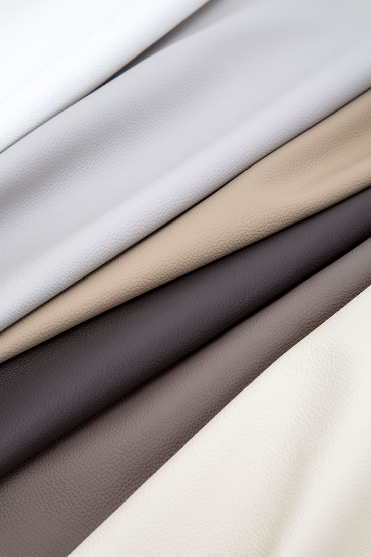 four different colors of leather on top of each other in close up view, including white and black