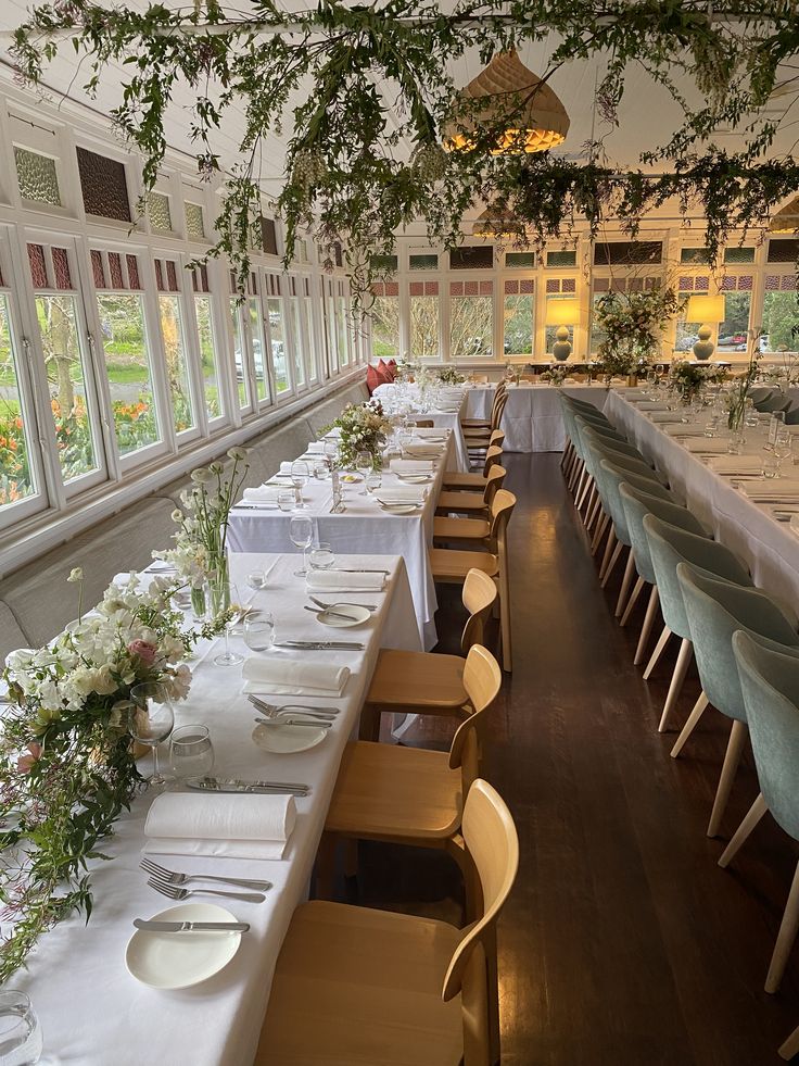 the long table is set with many plates and place settings