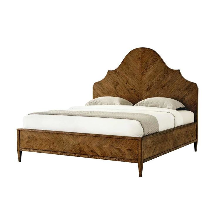 a bed that is made up with wood and white linens on the headboard