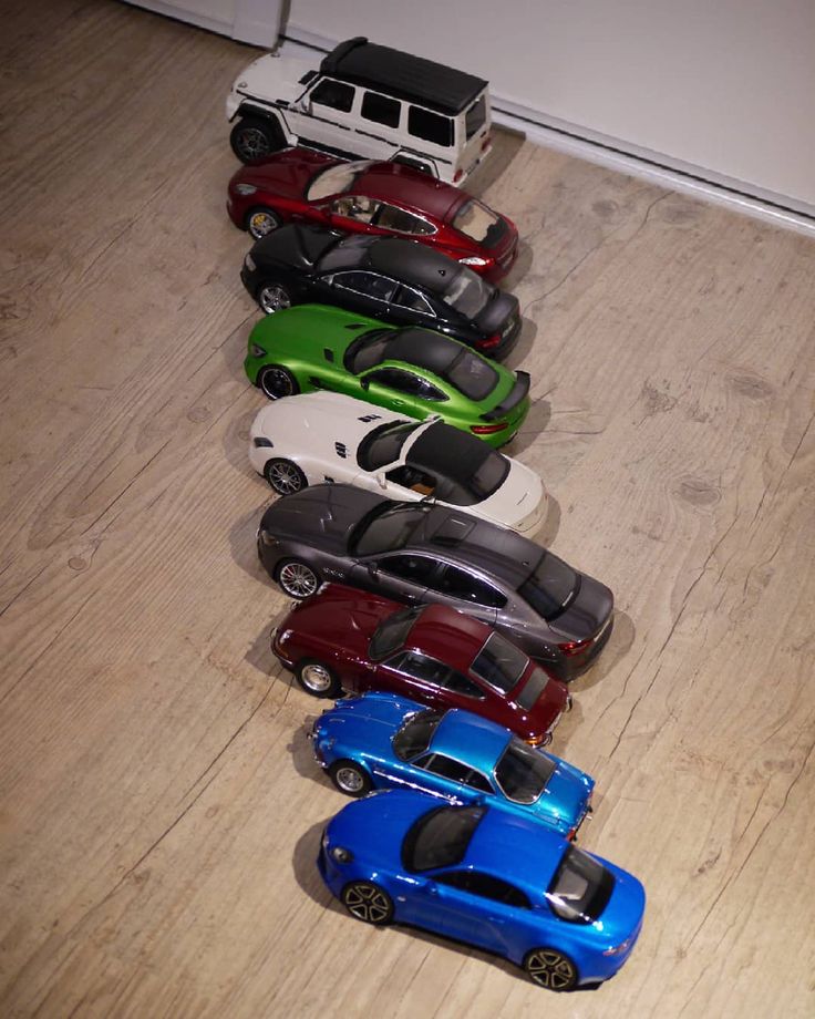 a row of toy cars sitting on top of a wooden floor