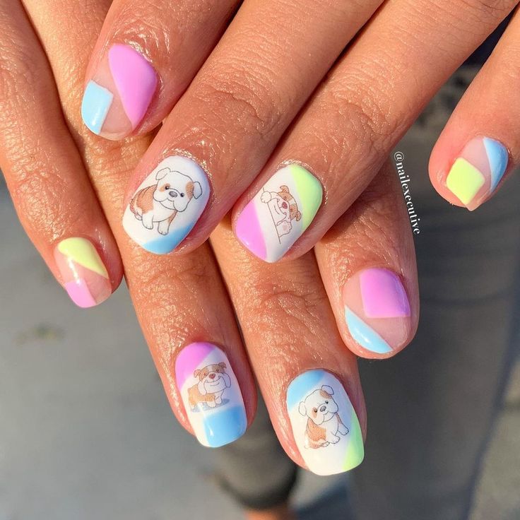 a woman's hand with colorful nail polish and an image of a dog on it