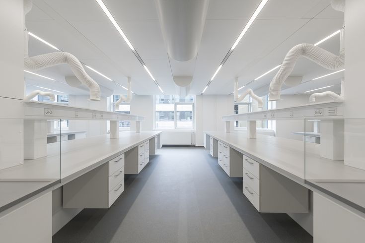 an empty room with white cabinets and drawers on the walls is lit by recessed lights