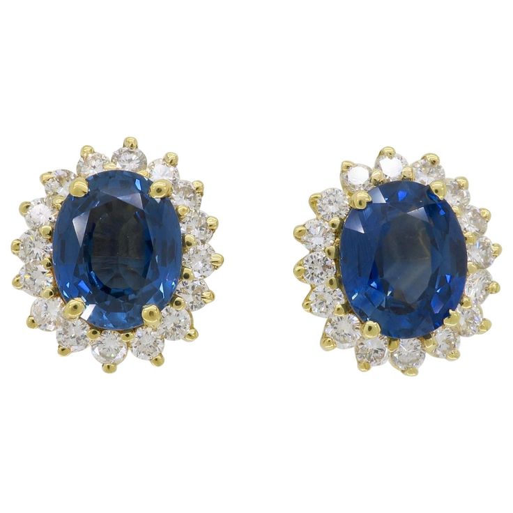 Blue Sapphire and 1.60CTW Round Brilliant Cut diamond halo style earrings in yellow gold. Gemstone: Blue Sapphire & Diamond Gemstone Carat Weight: Two Approximately 9.7x7.8mm Blue Sapphires Diamond Carat Weight: Approximately 1.60CTW Diamond Cut: Round Brilliant Cut Color: Average G-I Clarity: Average VS-SI Metal: 18K Yellow Gold Earrings with 14K Yellow Gold Posts and Backs Marked/Tested: Backs and Posts Stamped "14K”and earring baskets tested 18K Weight: 5.5 Grams Earring Length: Approximately Diamond Halo Earrings, Wedding Earrings Studs, Halo Diamond Earrings, Wedding Studs, Sapphire Studs, Halo Earrings, Halo Style, Blue Sapphire Diamond, Diamond Carat