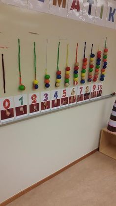 there is a wall display with numbers and beads on the pegs in front of it