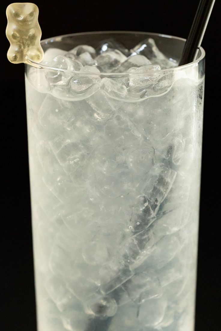 a glass filled with ice and a straw sticking out of it's top,