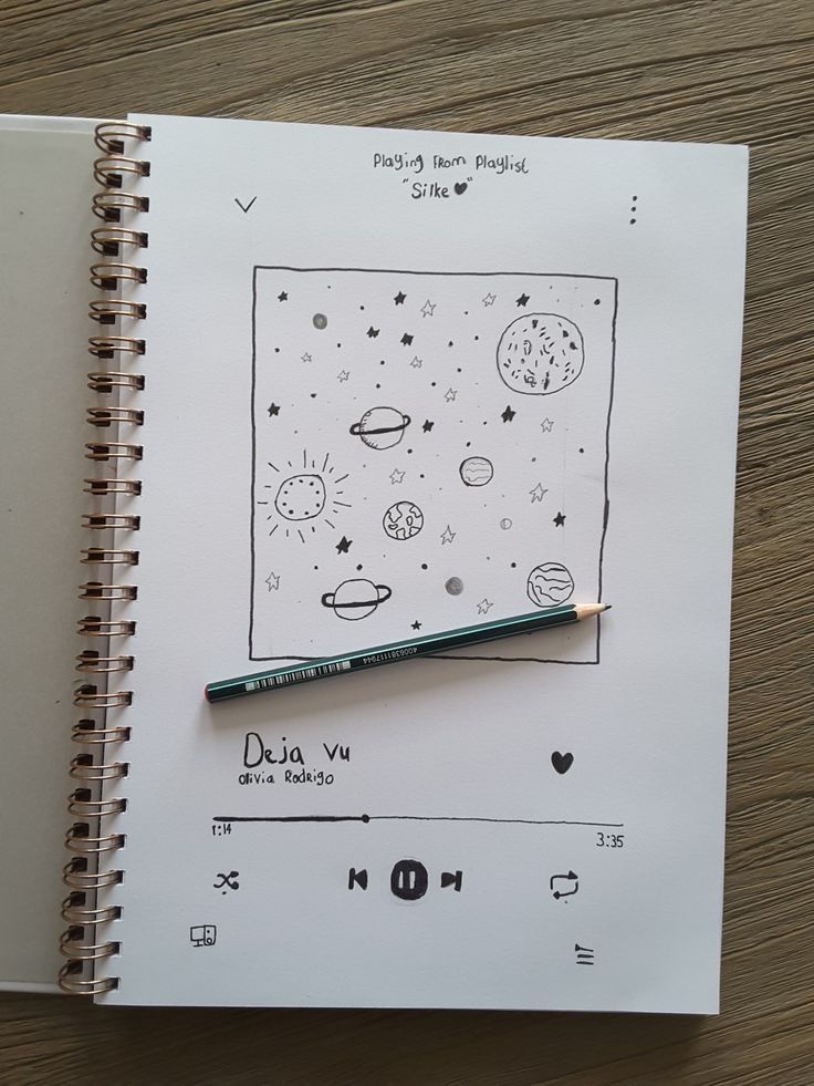 an open notebook with a drawing on it and a pencil in front of the page