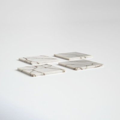 three white marble coasters sitting on top of each other in front of a white background