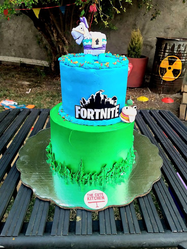 a three tiered cake sitting on top of a wooden table next to a tree