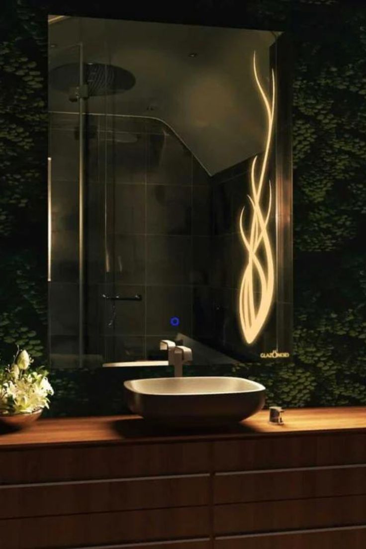 a bathroom sink sitting under a mirror next to a wall mounted faucet in front of a shower