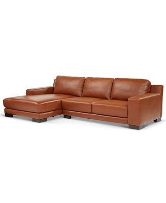 a brown leather sectional sofa sitting on top of a white floor