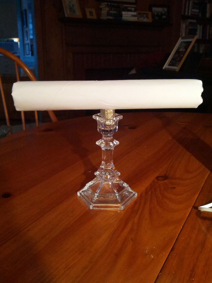 a glass candle holder sitting on top of a wooden table