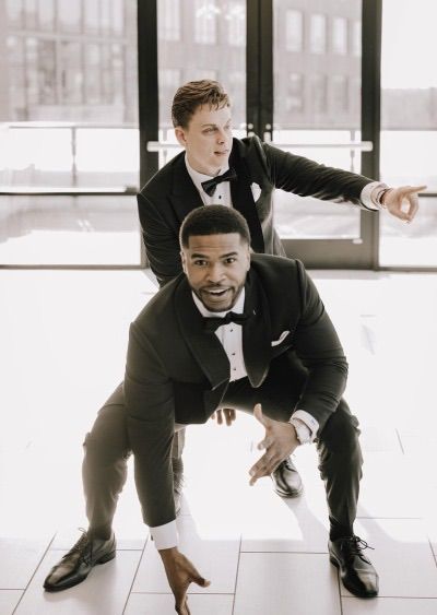 two men in tuxedos posing for a photo