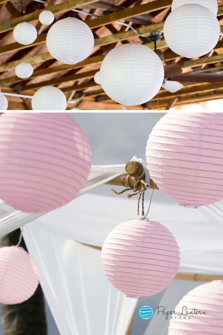 pink paper lanterns hanging from the ceiling in front of a wooden structure with white drapes