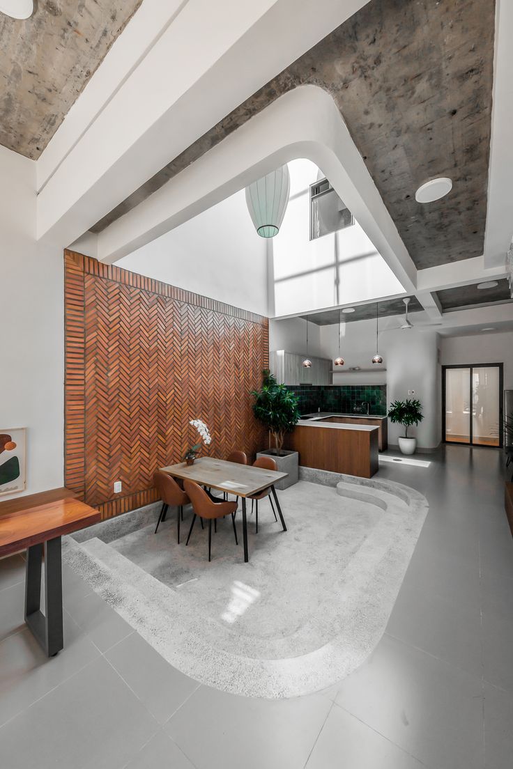 a room with a table, chairs and a wall in the middle that has wood paneling on it