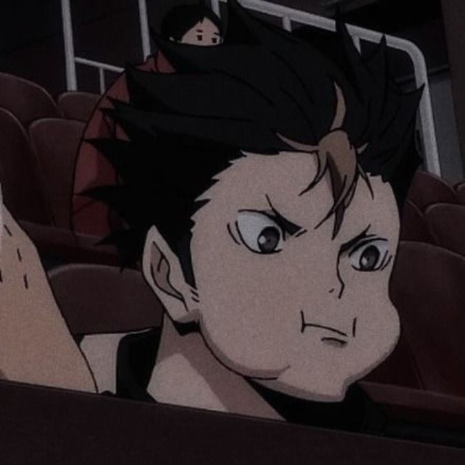 an anime character is sitting in the audience