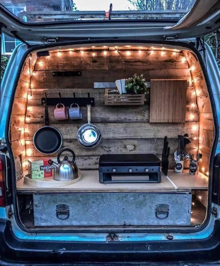 the back end of a van with lights on it's sides and an entertainment center in the trunk