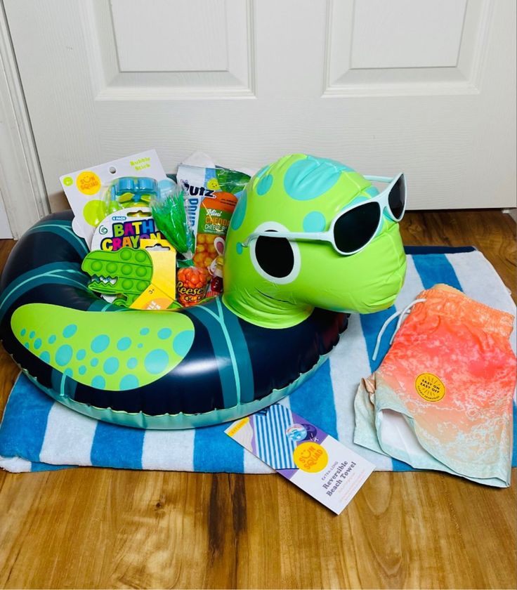 an inflatable sea turtle with sunglasses on it's head sitting on a towel next to a door