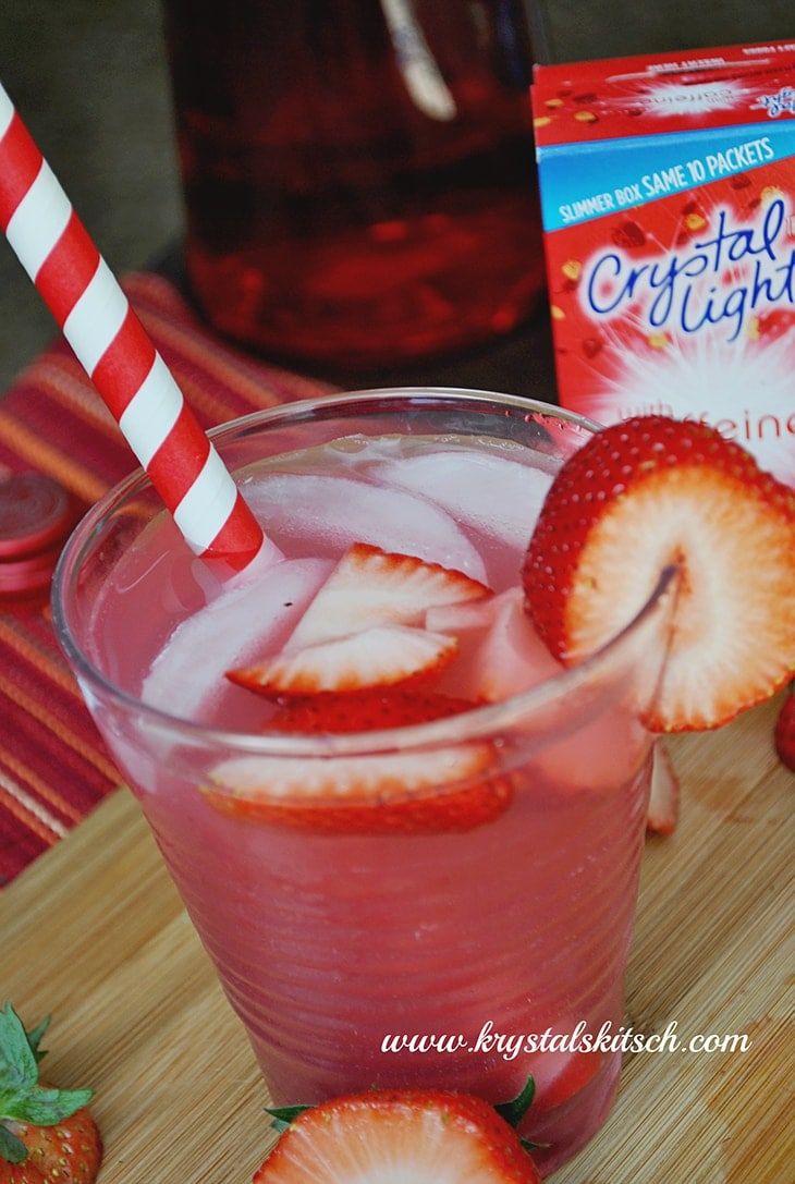 a drink with strawberries on the side and a carton of cranberry juice