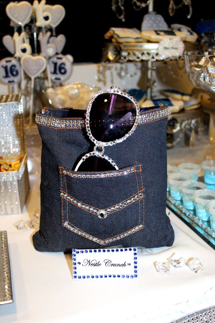 a denim bag with sunglasses in it sitting on top of a table