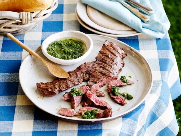 there is a plate with some meat on it and a bowl of pesto next to it