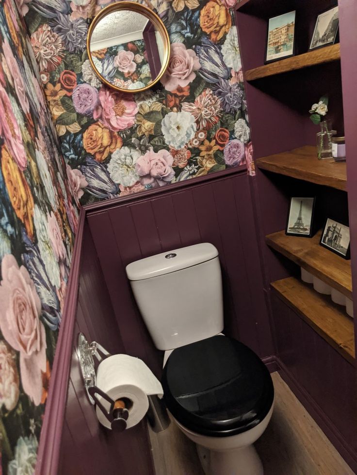 a bathroom with floral wallpaper and purple walls