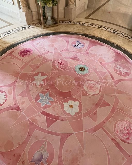 the floor is covered in pink and white flowers, which are surrounded by circular tiles