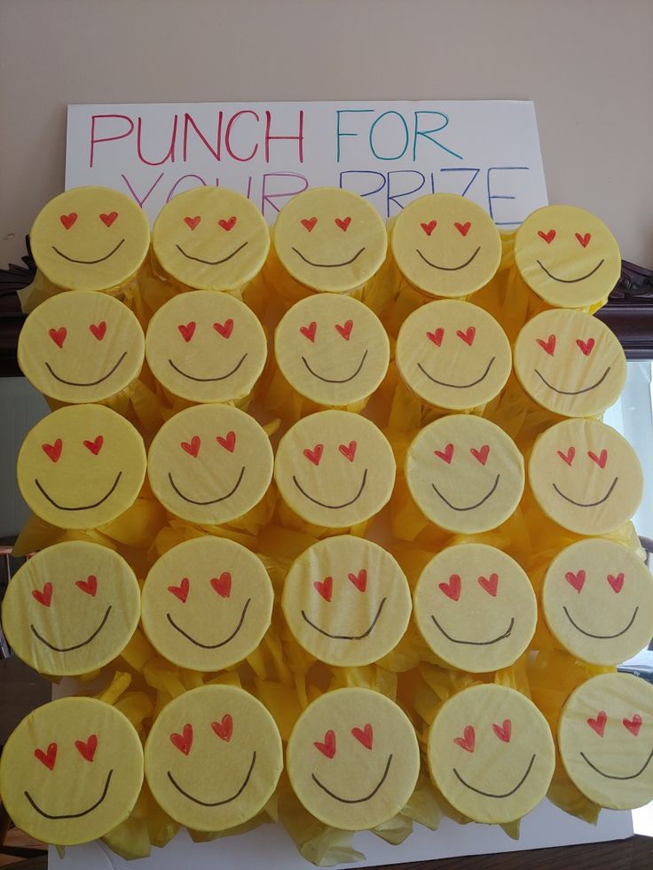 a bunch of smiley faces made out of yellow paper with red hearts on them and the words punch for your prize written below