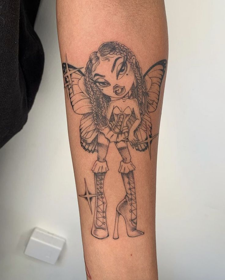 a woman's leg with a tattoo on it and a fairy holding a doll