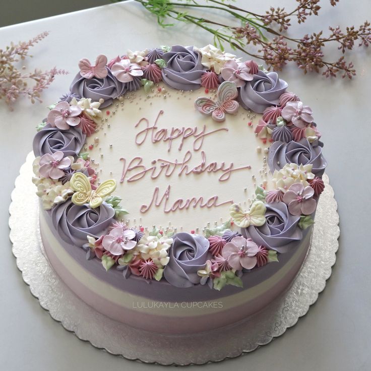 a birthday cake decorated with flowers and the words happy birthday mama on it's frosting