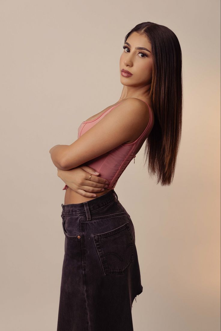 a woman with her arms crossed posing for the camera