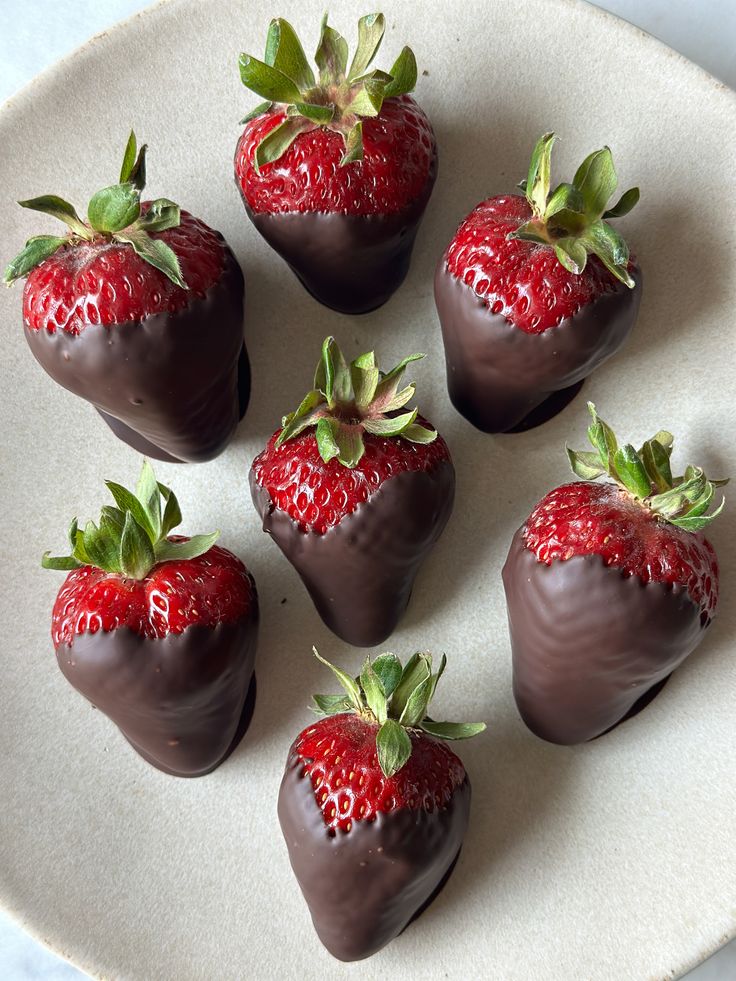 chocolate covered strawberries are arranged on a plate