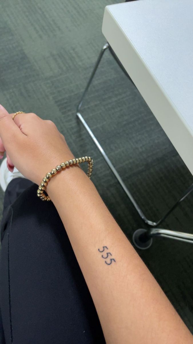 a woman's arm with a small tattoo on it and the number 35 written in cursive writing