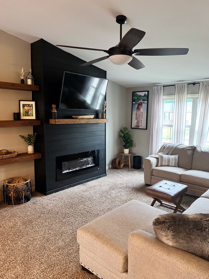 a living room with couches and a flat screen tv mounted on the wall in front of a fireplace