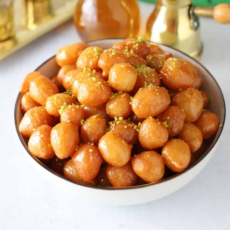 a white bowl filled with fried food sitting on top of a table next to other items