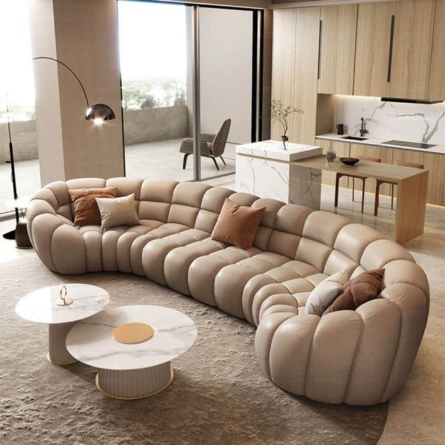 a large sectional couch sitting in a living room next to a kitchen and dining area