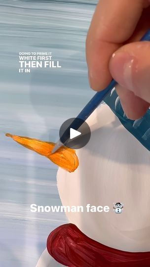 someone is painting a snowman face with paint