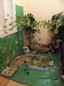 a room with green walls and plants on the floor