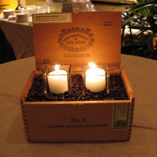 three lit candles in a wooden box on a table