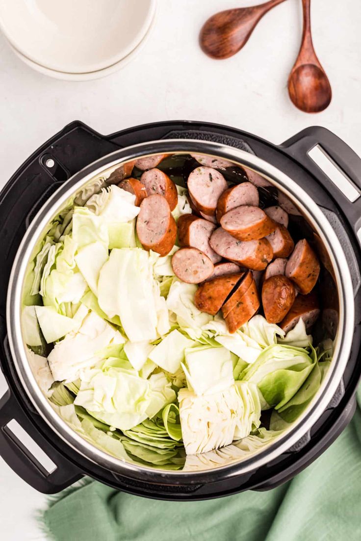 a pot filled with meat and lettuce next to a spoon