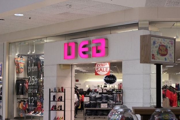 the inside of a clothing store with neon pink letters