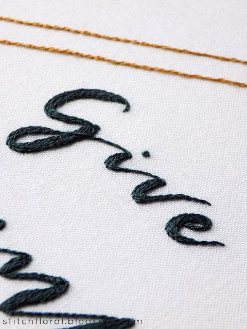 a close up of a cross stitch pattern with the word love written in cursive writing