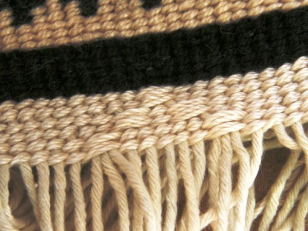 a close up view of a black and white rug with fringes on it's edges