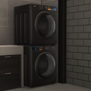 two black appliances sitting next to each other in a room with brick walls and flooring