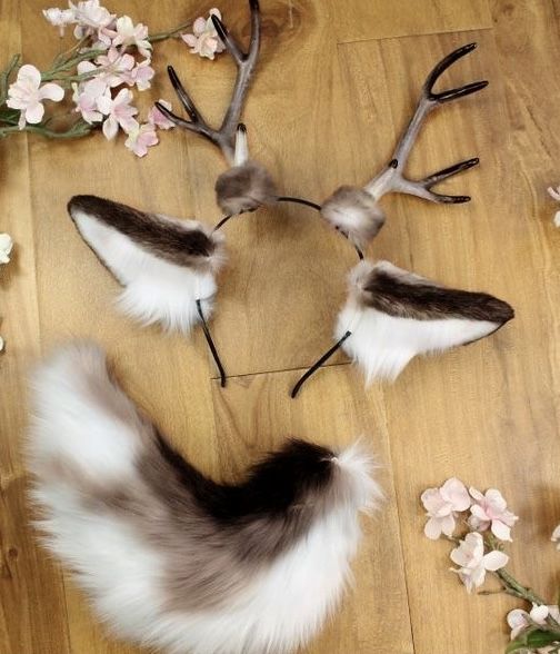 two deer antlers with fake fur and flowers on the floor in front of them