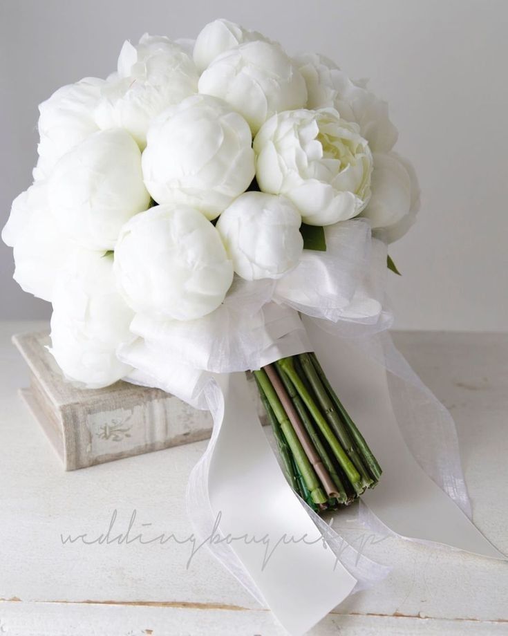 a bouquet of white flowers sitting on top of a table