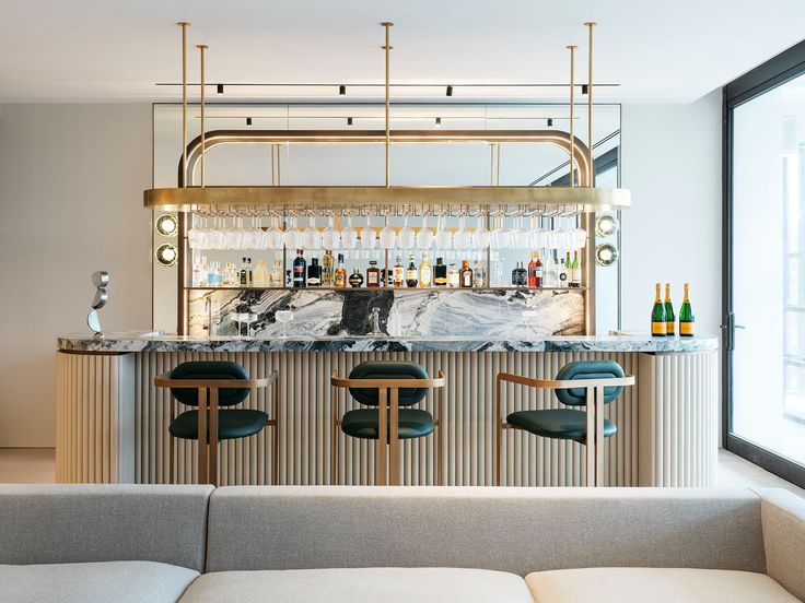 a bar with stools and bottles behind it